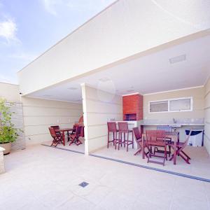 a patio with red chairs and a table at Elegante apto de 2/4 2004 in Goiânia