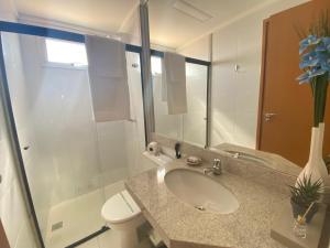 a bathroom with a sink and a toilet and a shower at Elegante apto de 2/4 2004 in Goiânia +12 photos