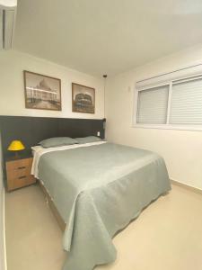 a bedroom with a large bed and a window at Elegante apto de 2/4 2004 in Goiânia