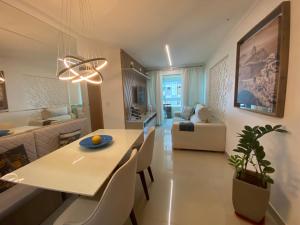 a dining room and living room with a table and chairs at Elegante apto de 2/4 2004 in Goiânia