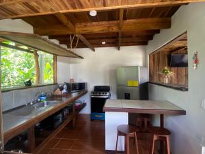 eine Küche mit einer Spüle und einer Theke mit Hockern in der Unterkunft Cabañas Litos #1 in Fortuna