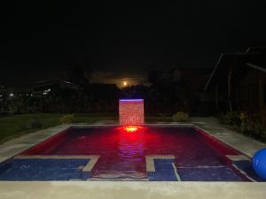 Una fuente iluminada en un patio por la noche en Cabañas Litos #1 en Fortuna