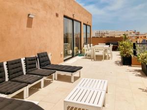 a patio with chairs and tables on a building at XL Terrace Penthouse BBQ 200m From The Sea and Square in St Paul's Bay