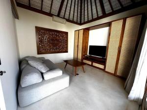 een woonkamer met een bank en een televisie bij Di Cappio Studio Uluwatu in Uluwatu