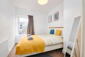 a bedroom with a bed with a yellow blanket at The Comfortable Cottage of The Dales - Sleeps 5 in Skipton