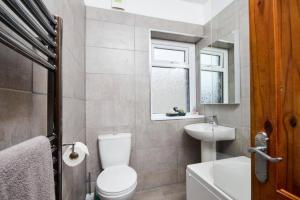 a bathroom with a toilet and a sink and a window at The Comfortable Cottage of The Dales - Sleeps 5 in Skipton