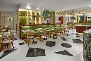 een restaurant met tafels en stoelen en een groene muur bij London Hilton on Park Lane in Londen