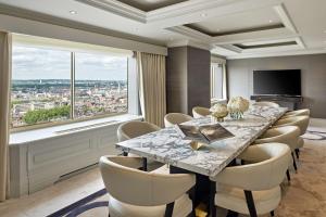 una sala da pranzo con tavolo, sedie e una grande finestra di London Hilton on Park Lane a Londra