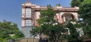 una casa rosa con una valla delante en Balaji Guest House - Home Stay, en Greater Noida