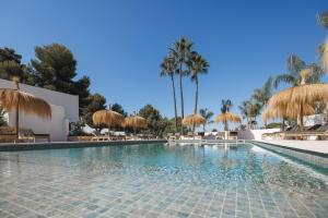 a swimming pool with chairs and umbrellas and palm trees at Boutique Hotel Los Limoneros in Moraira