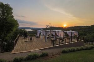 a deck with a bunch of umbrellas on it with the sunset at Itá Thermas Resort e Spa in Itá