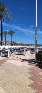 a group of tables and chairs on the beach at Apartament CullerA in Cullera