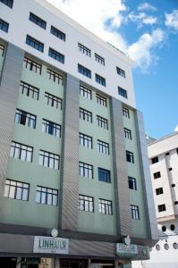 a large white building with windows at Hotel Linhatur in Linhares