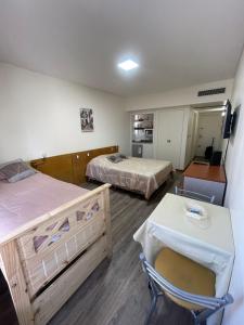 Habitación con 2 camas, mesa y silla en Mi Buenos Aires Querido en Buenos Aires