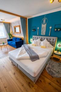 a bedroom with a large bed and a blue wall at Appartement Stelo Gosau-Hallstatt in Gosau