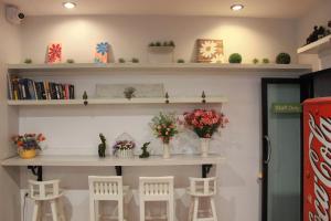 Habitación con estanterías blancas con flores y taburetes en Shan Boutique hotel en Chiang Mai