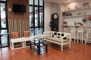 ein Wohnzimmer mit weißen Stühlen und einem TV in der Unterkunft Shan Boutique hotel in Chiang Mai