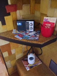una mesa con radio y revistas. en Backpack Cabin A 49149 en Oranjestad
