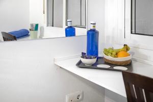 a counter with a bowl of fruit and two bottles at Casa Fluri in San Fernando