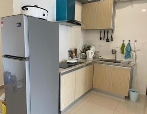 eine kleine Küche mit Kühlschrank und Spüle in der Unterkunft Skyville 8 @ Benteng in Kuala Lumpur