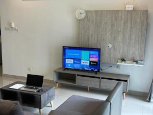 ein Wohnzimmer mit einem Flachbild-TV und einem Sofa in der Unterkunft Skyville 8 @ Benteng in Kuala Lumpur