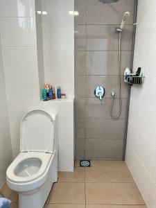 ein kleines Bad mit einem WC und einer Dusche in der Unterkunft Skyville 8 @ Benteng in Kuala Lumpur