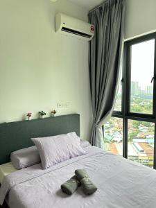 ein Bett mit zwei Handtüchern und einem Fenster in der Unterkunft Skyville 8 @ Benteng in Kuala Lumpur