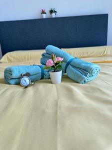 einen Haufen Handtücher und eine Pflanze auf dem Bett in der Unterkunft Skyville 8 @ Benteng in Kuala Lumpur