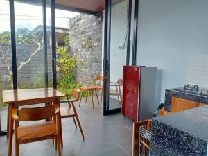 een keuken met een tafel en stoelen en een koelkast bij Semanggi Private Villa in Ubud