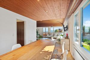 a dining room with a large wooden table and chairs at Luxus Loft am Zürichsee I Seesicht I Garten I Arbeitsplatz in Richterswil