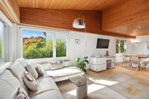 a living room with a couch and a table at Luxus Loft am Zürichsee I Seesicht I Garten I Arbeitsplatz in Richterswil