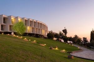 a building on a hill with lights in the grass at Elma Hotel and Art Complex in Zikhron Ya'akov