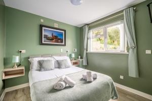 a green bedroom with a large bed with towels on it at Chamberlain House in Derry Londonderry