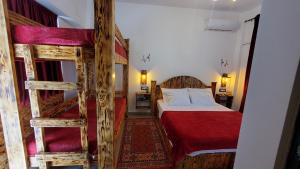 a bedroom with two bunk beds and a red bedspread at Clockwise GuestRooms in Gjirokastër