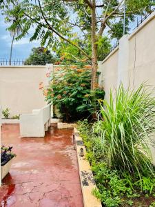 un giardino con panchina bianca e alcune piante di Nakupenda a Mazizini
