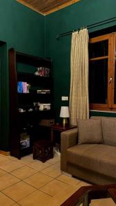 un soggiorno con divano e parete verde di Loukia's Place a Vytina