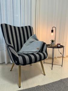 a black and white chair sitting next to a table at WINDSOR PLACE APARTMENT - SELF CHECKIN with CODE in Athens