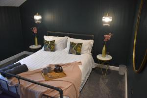 1 dormitorio con 1 cama y 2 mesas con jarrones en Luxury 2-Bed Barn Conversion in Llansteffan, en Carmarthen