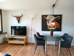 una sala de estar con una mesa y una foto de una vaca en Camenzind, en Gersau