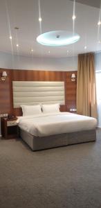 - une chambre avec un grand lit et un grand couvre-lit blanc dans l'établissement فندق اجيال المدينة 1-Ajyal Al Madina Hotel 1, à Médine