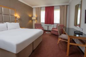 a hotel room with a large bed and a desk at Stratford Manor Hotel in Stratford-upon-Avon