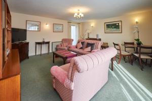 a living room with pink furniture and a dining room at Host & Stay - Grange Cottage in Belford