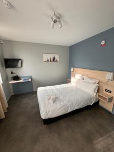 - une chambre avec un lit et un ventilateur de plafond dans l'établissement L'Hirondelle, 