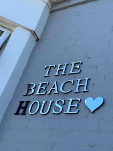 ein Schild an der Seite eines Gebäudes mit Herz in der Unterkunft The Beach House in Lowestoft