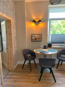 オスナブリュックにあるKatharina Boardinghouseのテーブルと椅子、窓が備わる客室です。