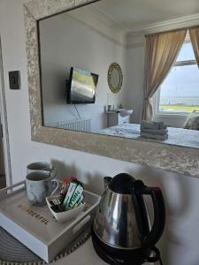 a mirror on a counter with a tea kettle on a tray at The Beach House in Lowestoft