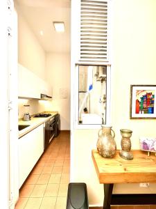 cocina con armarios blancos y mesa de madera en Casa Rambla Serra Cali, en Cali