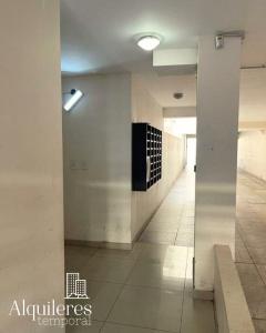 pasillo en un edificio con paredes blancas y suelo de baldosa en tucuman 2660 en Rosario