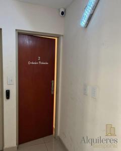 Una puerta marrón en un edificio con un cartel. en tucuman 2660 en Rosario