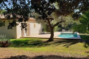 una casa con un árbol y una piscina en Charmante Villa Ipsilon, jardin arboré provençal !, en Le Luc